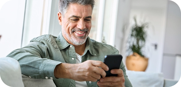 Homem sentado no sofá usando o celular