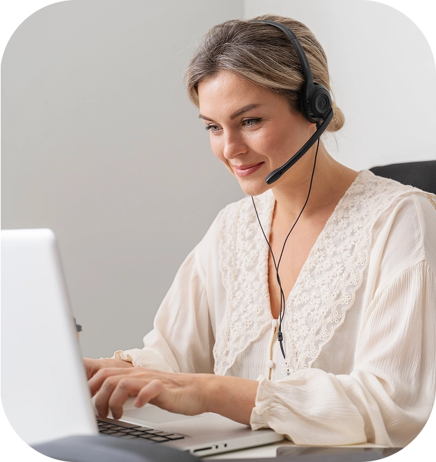 Atendente da Quita com headset sorrindo em frente ao computador